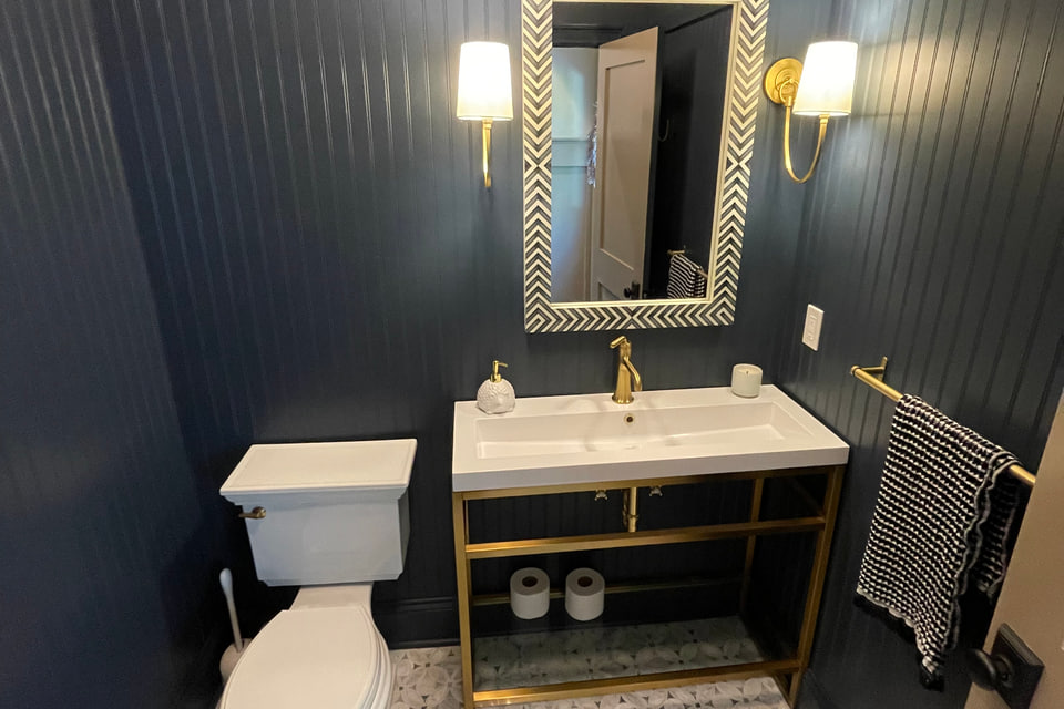 Dark bathroom with vertical wall paneling and a custom vanity