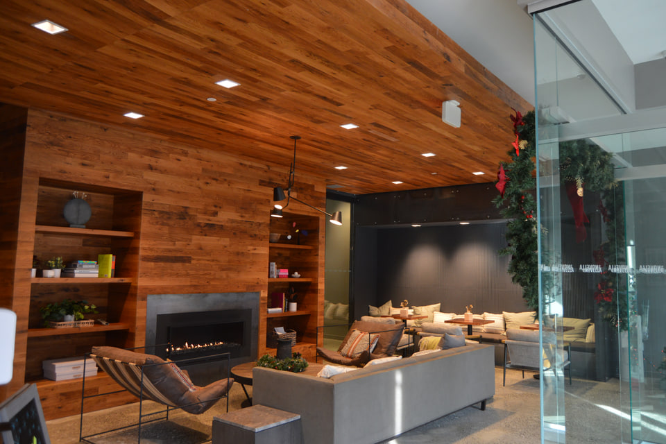 Commercial lobby with wood ceiling, wall cladding, built-in shelving and a fireplace