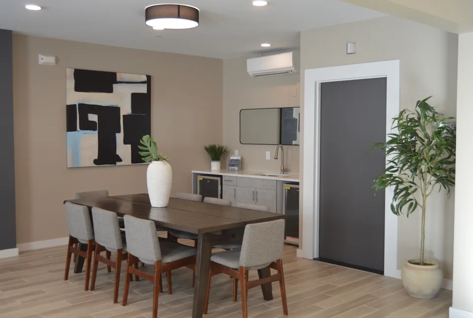 Dining area with low cabinets, a countertop, open wall shelves and trimmed door openings.