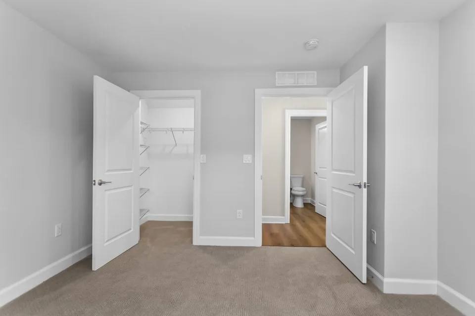 White interior room with paneled doors, door casing and baseboards.