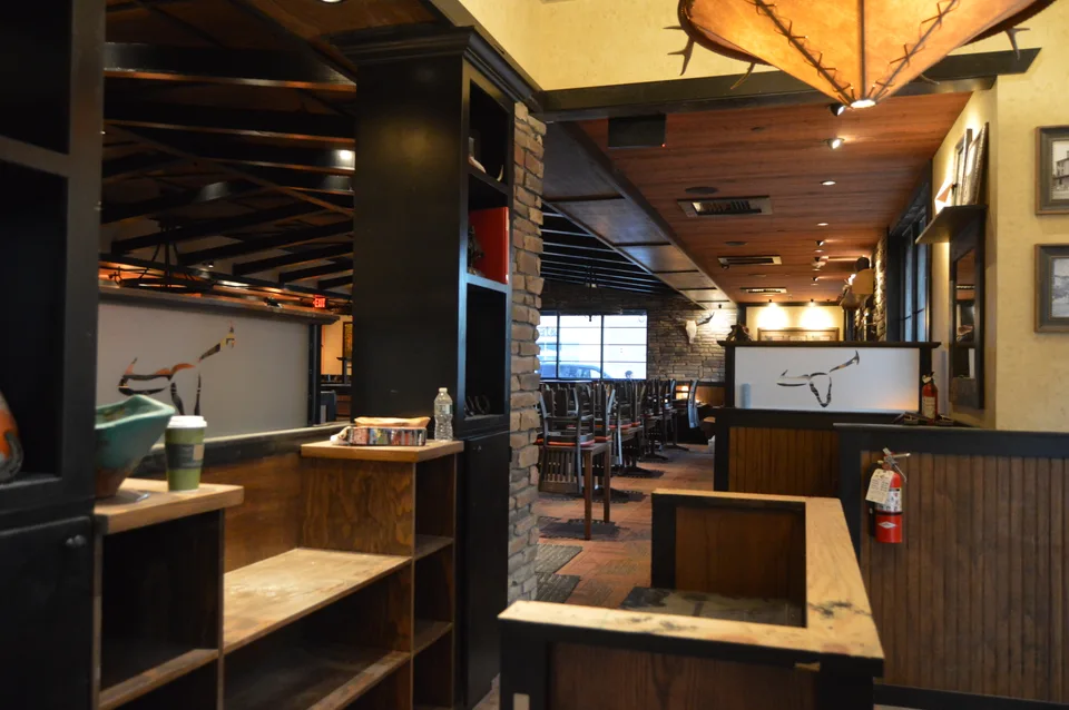 Restaurant interior with wood booth partitions, trim and exposed ceiling details.