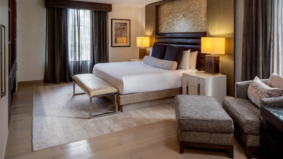 Guest room with a framed headboard wall, bedside cabinetry and interior trim.