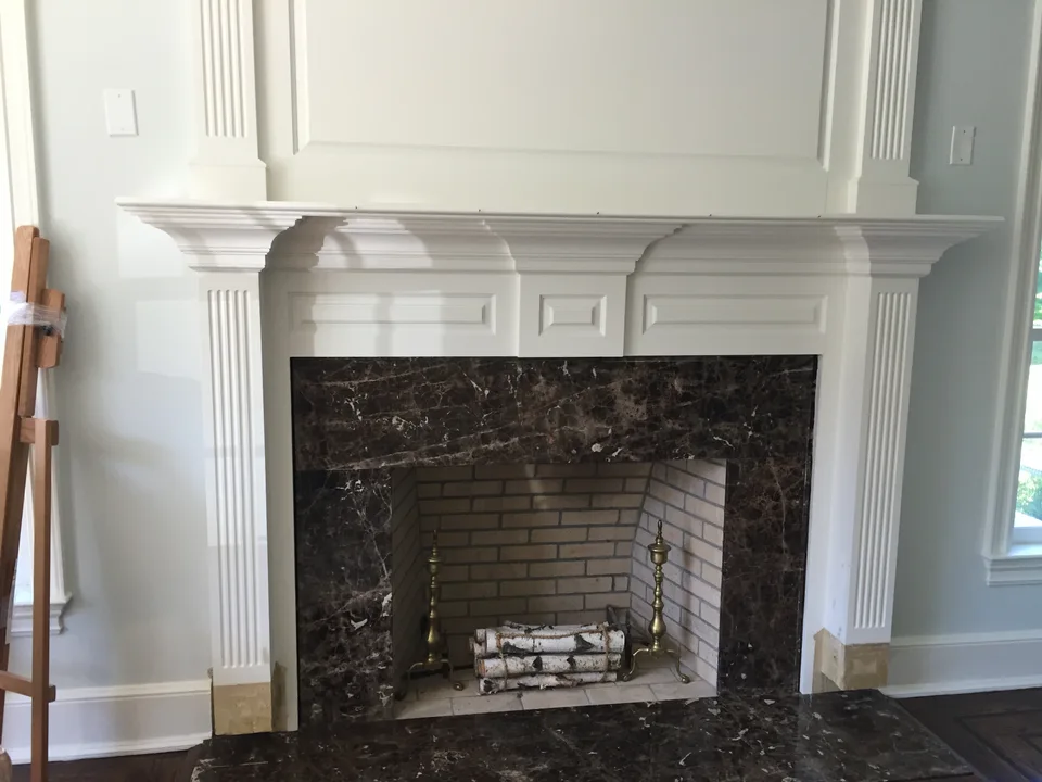 White fireplace surround with fluted vertical trim and layered mantel molding.