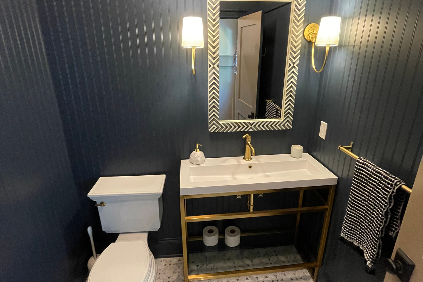 Dark bathroom with vertical wall paneling and a custom vanity