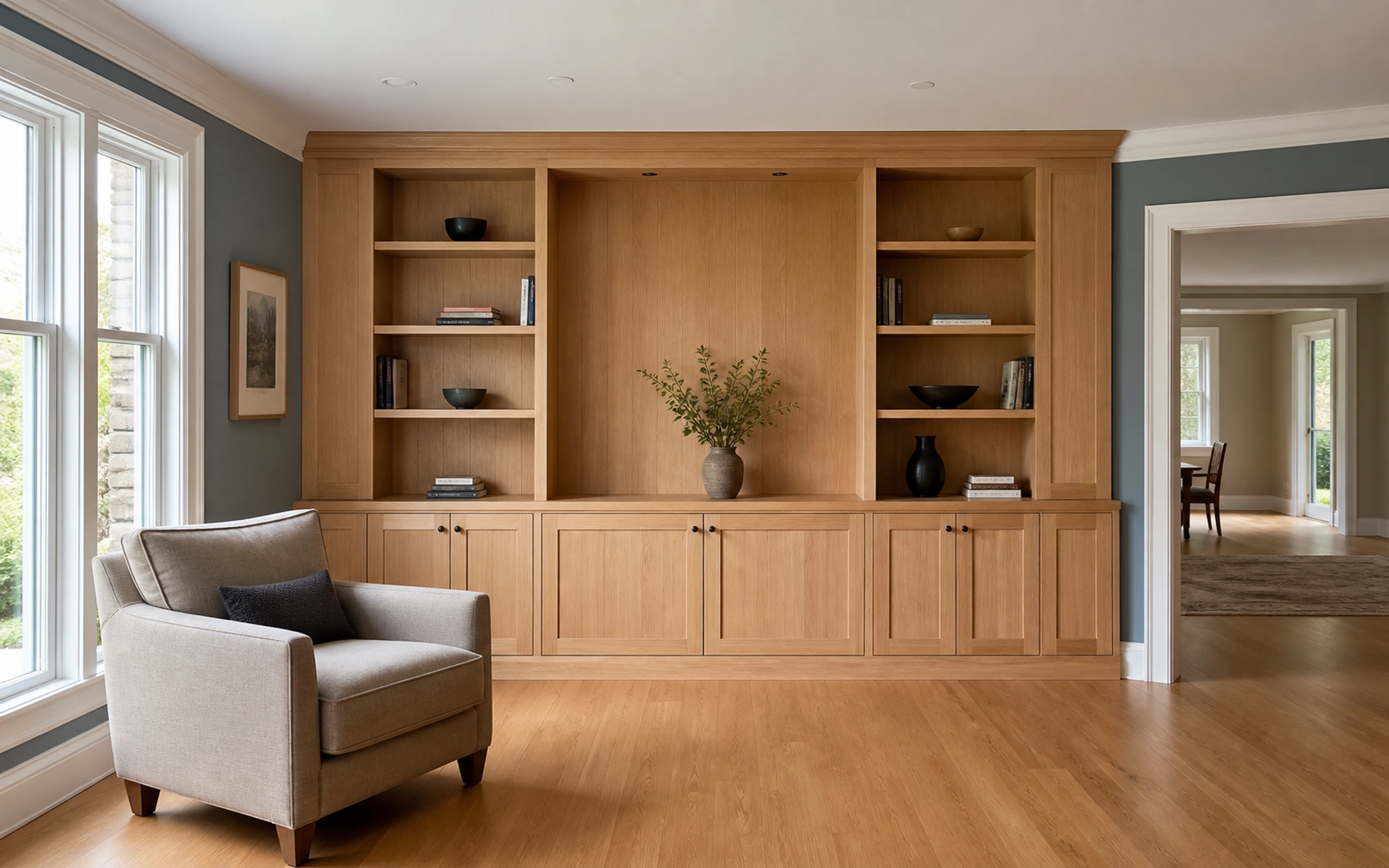 Oak built-in shelving and lower cabinets beside a living room doorway.