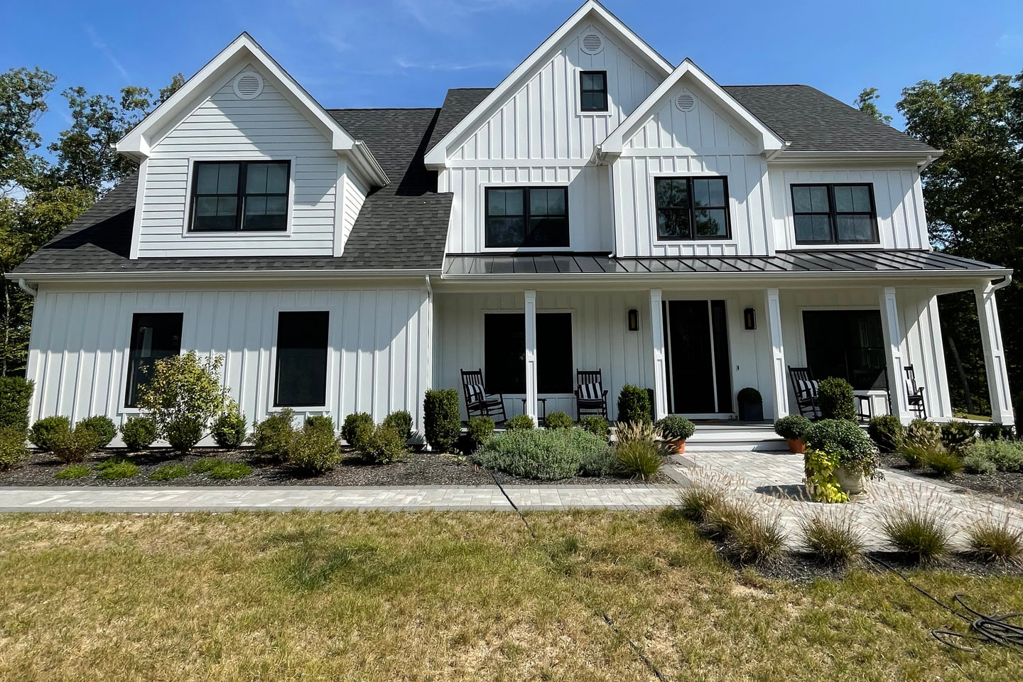 White two-story home with detailed exterior trim and board-and-batten siding